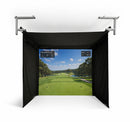 A golf simulator setup with a black fabric enclosure and displaying a golf course on the screen.