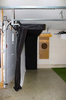 A side view of black curtains and a screen installed on a garage ceiling.