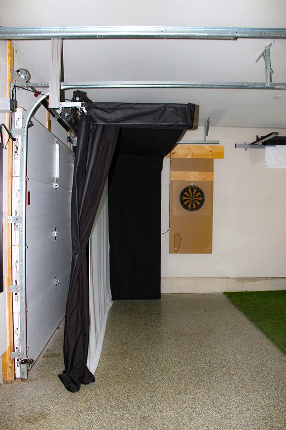 A side view of black curtains and a screen installed on a garage ceiling.