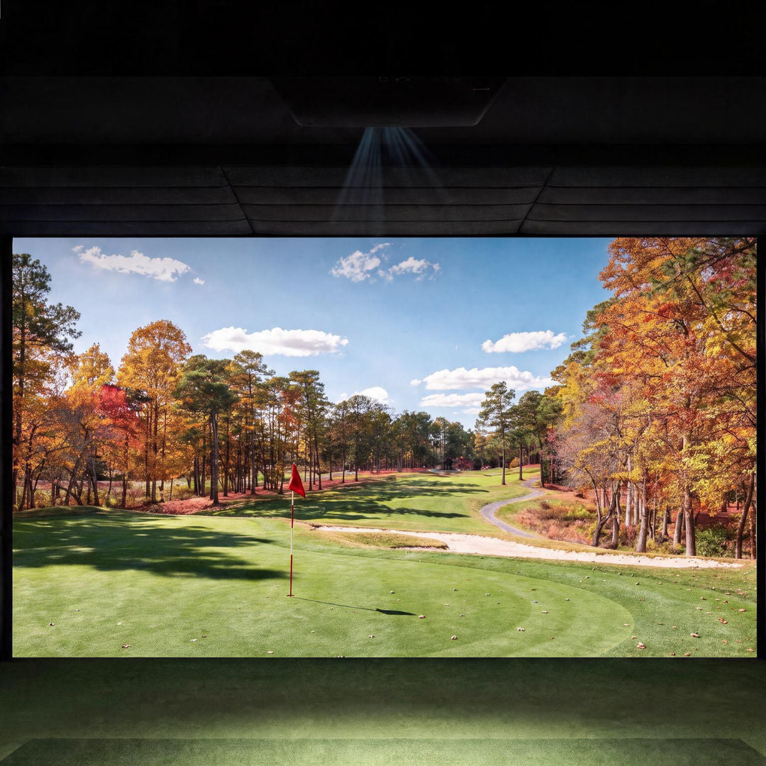 BenQ AK900ST 4K laser golf projector showing a realistic golf course image on a simulator screen