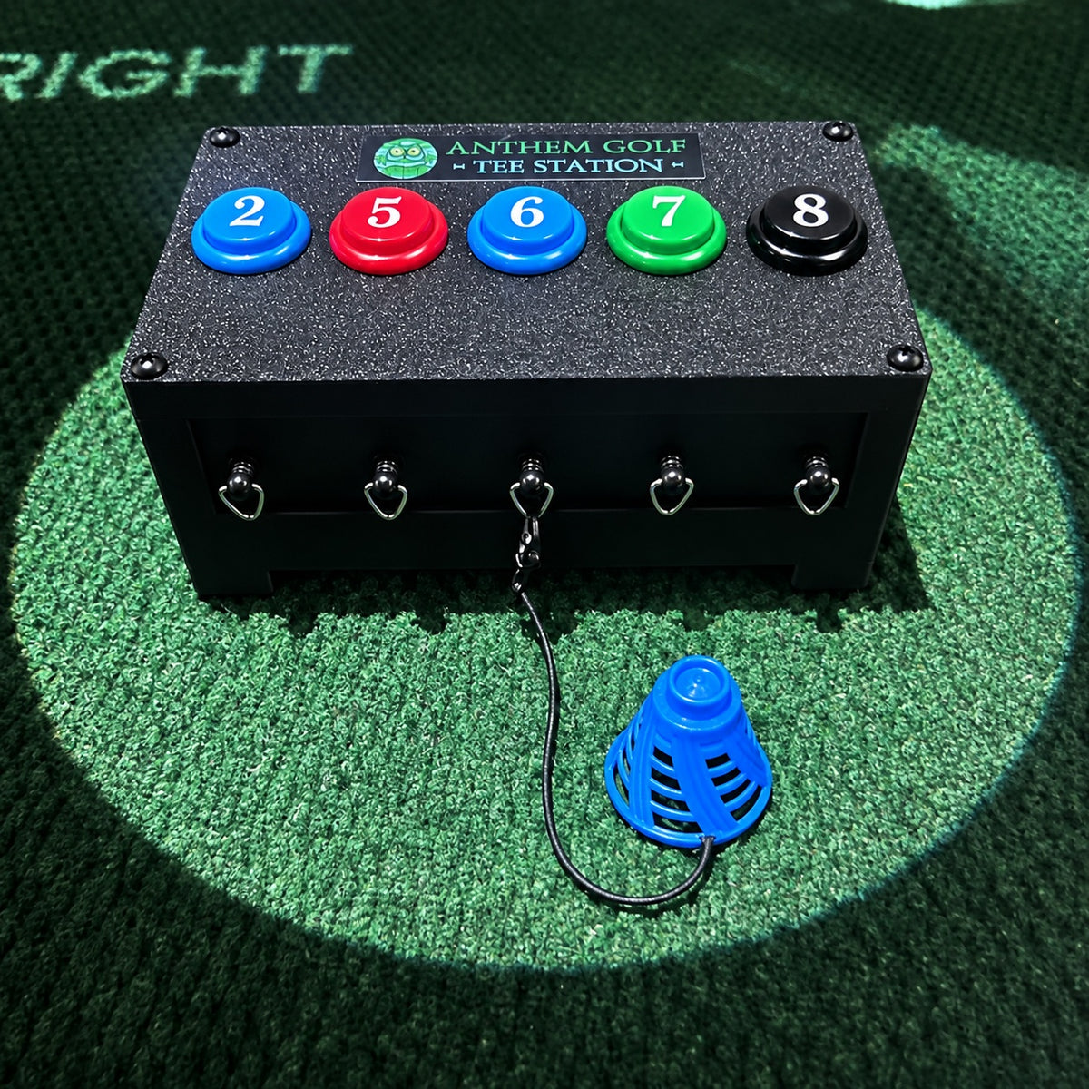 Anthem Golf Tee Station Birtee Edition on a simulator hitting mat, numbered color matched buttons with a blue size 6 Birtee on the middle tether