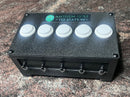 A black control box with five white push buttons on top and five silver terminal screws on the front, branded 'ANTHEM GOLF TEE STATION'.
