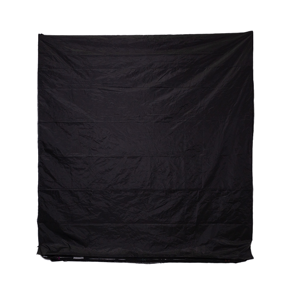 A large, crumpled black fabric sheet hangs against a plain white background.