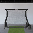 A golf practice net is set up indoors with a green mat and a golf bag nearby.