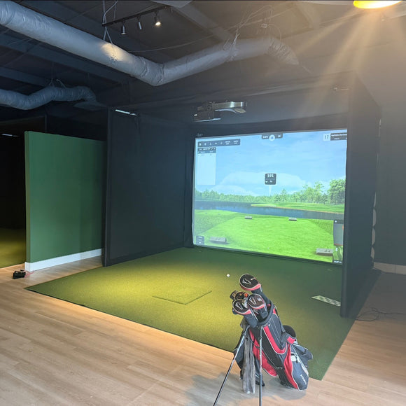 Rain or Shine Golf Studio Turf Sim Flooring Kit covering a golf simulator bay floor with a golf bag in front
