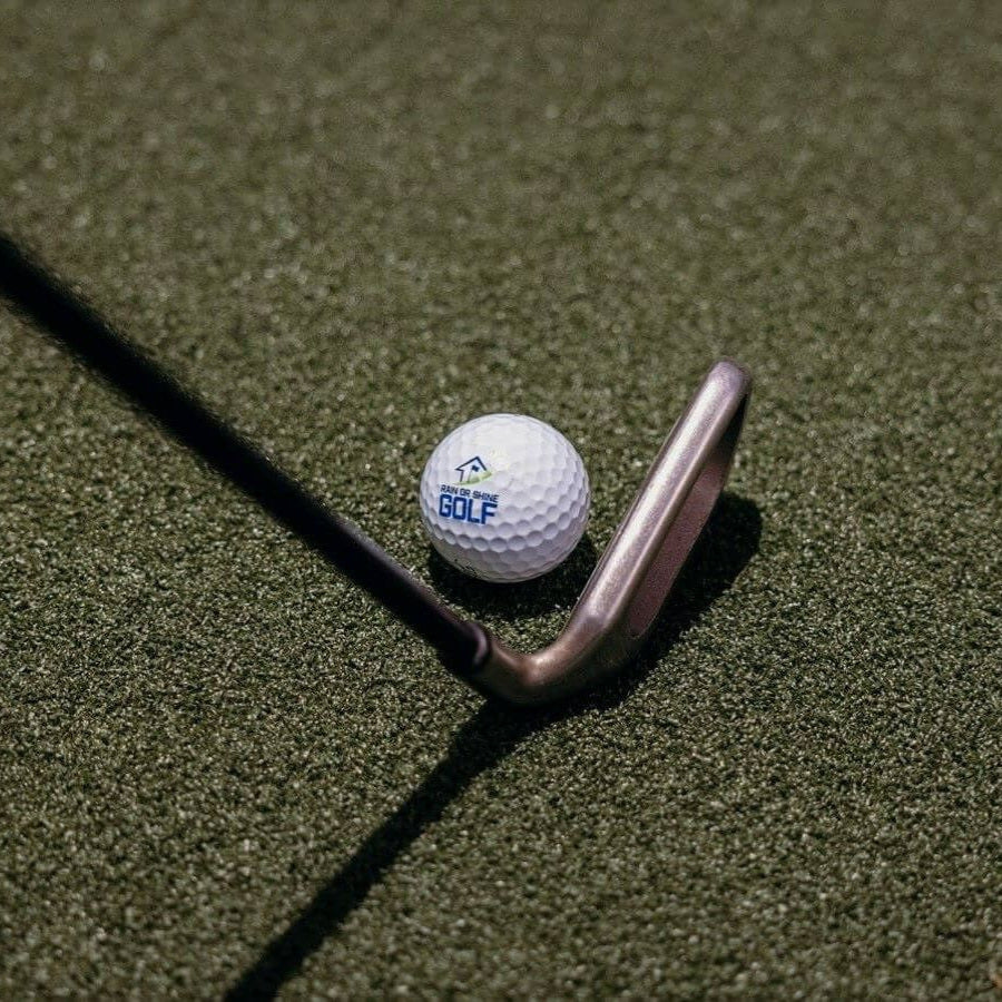 Iron and golf ball resting on SwingTurf fairway feel turf